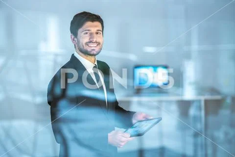 The happy businessman stand with a tablet near the window Stock Photos