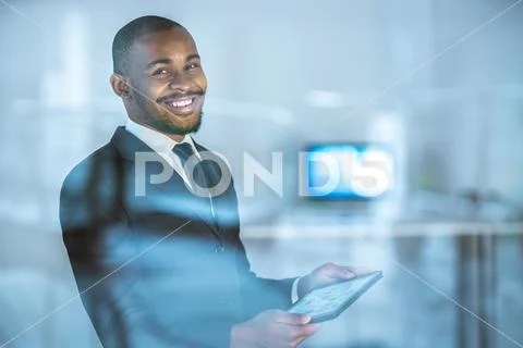 The happy businessman stand with a tablet over the window Stock Photos