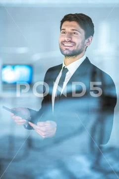 The happy businessman stand with a tablet over the window Stock Photos