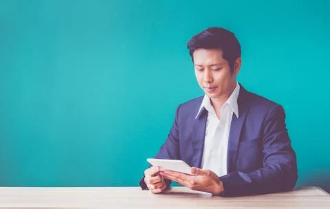 Happy businessman using tablet computer on desk at office,success business pl Stock Photos
