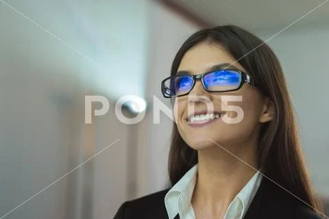 The happy businesswoman with glasses against the background of the projector Stock Photos
