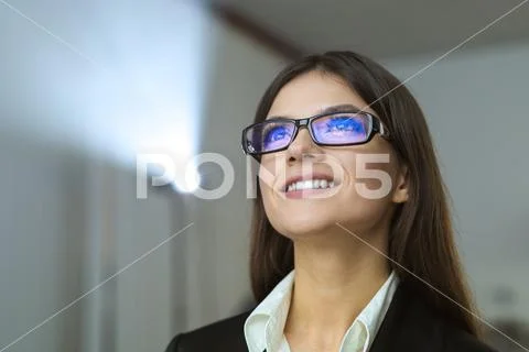 The happy businesswoman with glasses on the background of projector Stock Photos
