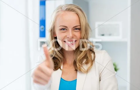 Happy businesswoman showing thumbs up at office Stock Photos
