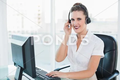 Happy call centre agent sitting on swivel chair Stock Photos