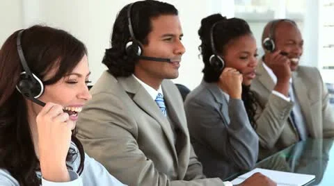Happy call centre agents wearing headsets Stock Footage