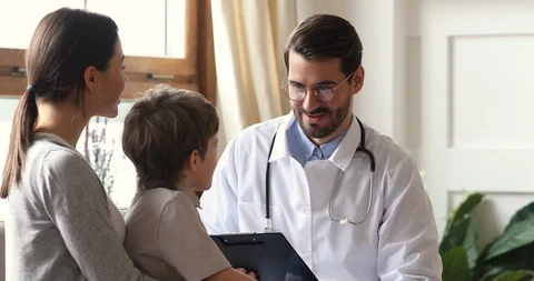 Happy caring male doctor encouraging kid boy patient at checkup Stock Footage