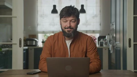 Happy caucasian bearded guy working on the laptop computer Stockbeeldmateriaal 201084427
