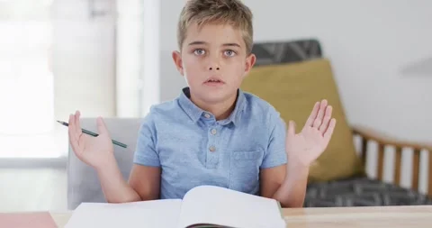 Happy caucasian boy sitting at table, having online lesson, slow motion Stock Footage 337932320