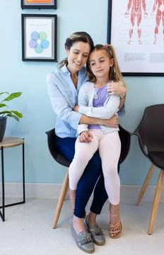 Happy caucasian daughter patient sitting on mother's lap embracing in hospi.. Stock Photos