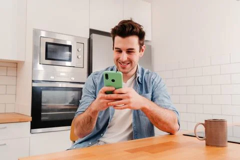 Happy caucasian guy using his smart phone chatting sending messages on social Stock Photos