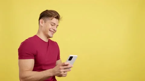 Happy caucasian man with brackets smiling while using a mobile 動画素材 234913751