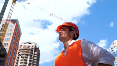 Happy Caucasian man engineer using walkie-talkie while talking in construction Foto stock