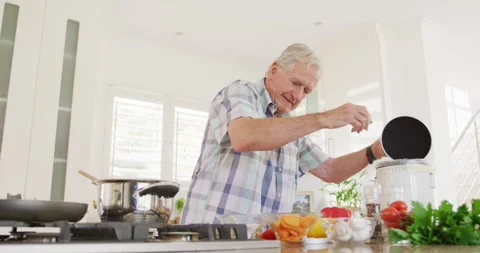 Happy caucasian senior man throwing waste out and cooking in kitchen Stock Footage 337623529