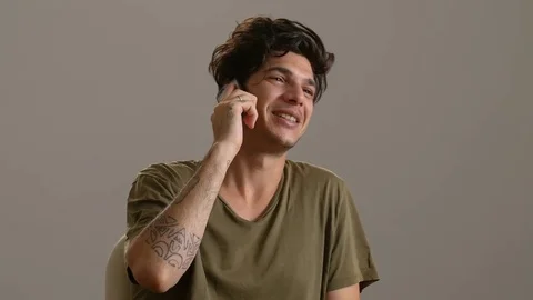 Happy charming young man talking by phone- indoor Stock Footage