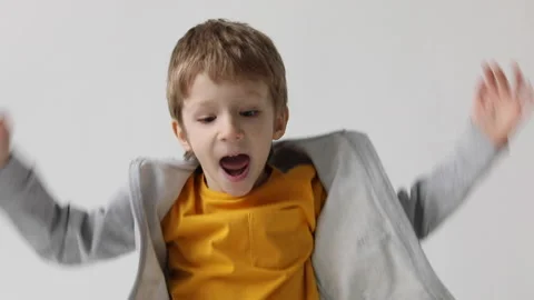 Happy cheerful boy close-up joyfully jumping waving his arms, celebrating vic Stock Footage 168907209