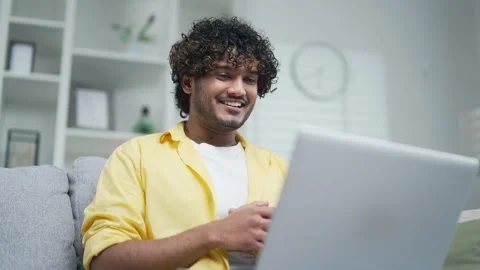 Happy cheerful guy communicates online with family or friends via video call  Stock Footage 235489620