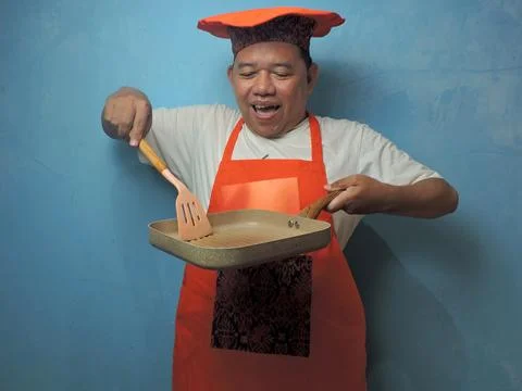 Happy Chef Stirring in Empty Pan with Cooking Utensils Stock Photos