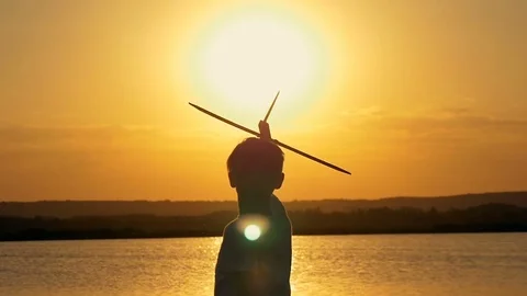 Happy child on a background of an orange sky and lake in summer at sunset Video stock 80211229
