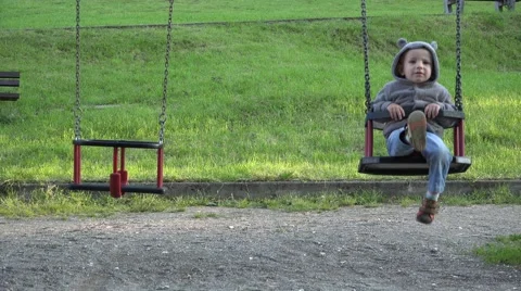 Happy child balancing in swing close empty swing 4K Video stock 46207574