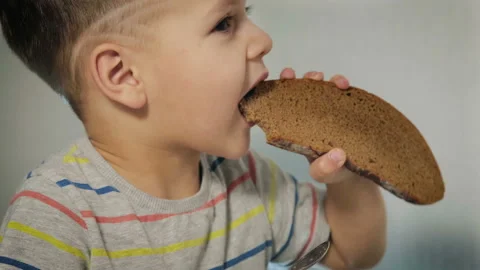 Happy child bites a piece of bread Stock Footage 101874757