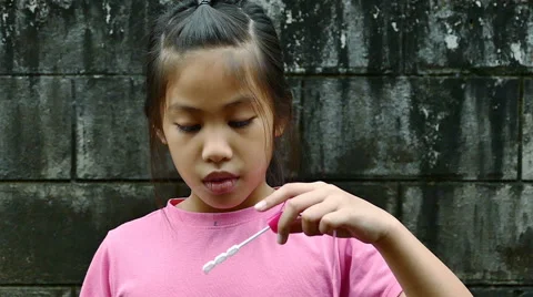 Happy child blowing soap bubbles in spring park. Slow motion Video stock 65802232