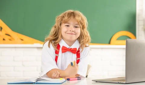 Happy child boy in bow tie study in school classrrom at blackboard, back to Stock Photos