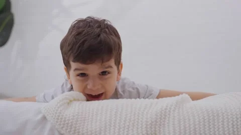 Happy child boy having fun in bedroom in the morning Stock Footage 244342713