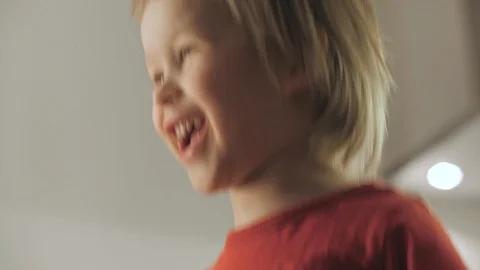 Happy child boy jumping having fun feeling positive emotion low angle Stock Footage 129680590