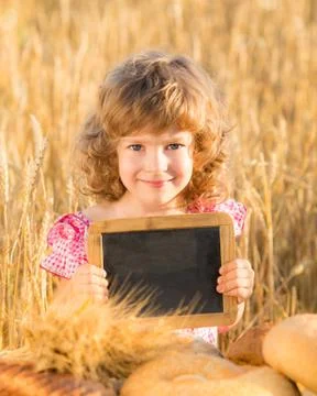 Happy child with bread in field Stock Photos