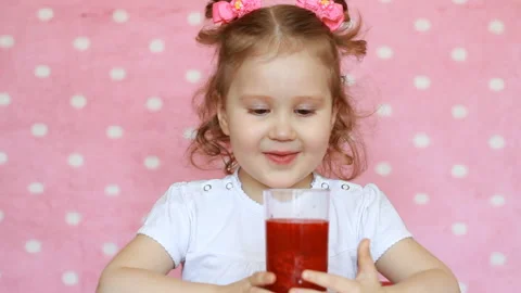 Happy child drinks smoothies and smiles. Close-up portrait of a cute girl who Stock Footage 88317474