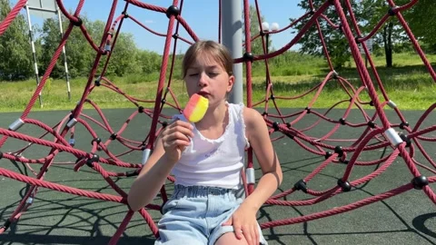 A happy child eats ice cream while relaxing in the park on a summer day, Stock Footage 244326425