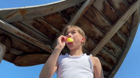 A happy child eats ice cream while relaxing in the park on a summer day, Stock Footage 244326474