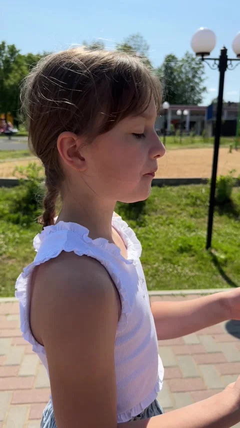 A happy child eats sweet cotton candy at an amusement park on a summer day, a Stock Footage 244320480