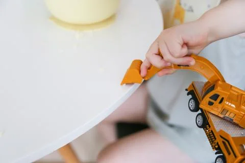 Happy child eats at the table on his own. Healthy food, the boy feeds the c.. Stock Photos