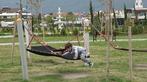 Happy child gets on hammock and swings Video stock 106517522