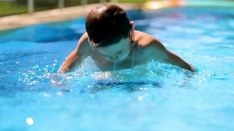 Happy child going underwater inside swimming pool water Stock Footage 117549231