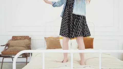 Happy child having fun and jumping on white bed Stock Footage 130780572