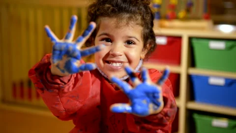 Happy child having fun and painting with hands in kindergarten Stock Footage 219776565