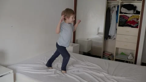 Happy child having fun jumping on the bed Stock Footage 316252033