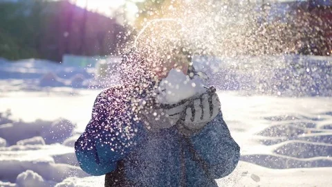 Happy child having fun in winter Park on a Sunny day.Blows the snow from the Vidéo 70700525