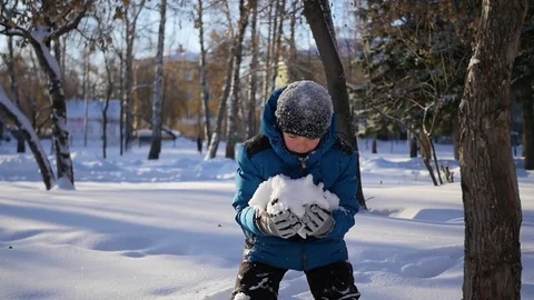 Happy child having fun in winter Park on a Sunny day. Throwing snow over himself 库存影片 70703232
