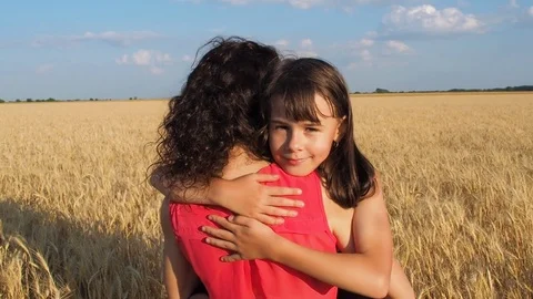 A happy child is hugging her mother in a wheat field. Stock Footage