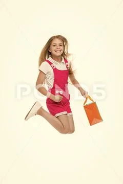 Happy child jump with shopping bag isolated on white. Little shopaholic smile Stock Photos