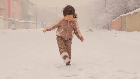 Happy Child Jumping with Joy in Falling Snow Stock Footage 295766569