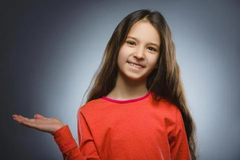 Happy child keeps on hand something. Closeup Portrait of handsome girl smiling Stock Photos