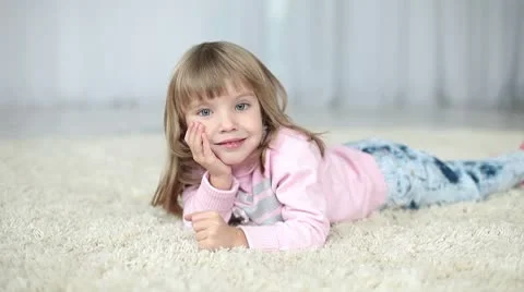 Happy child lying on a carpet. Looking at camera Stock Footage 8975207