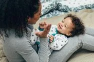 Happy Child Lying On Mother Hips. Mother Playing With Son. Stock Photos