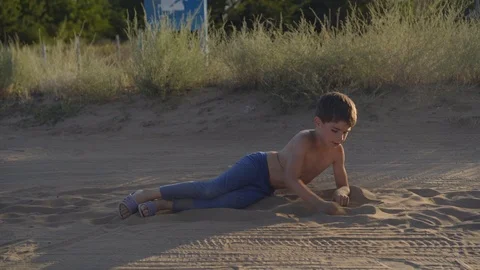 Happy child is lying in steppe dust and sand, enjoy free play Vidéo 104499357
