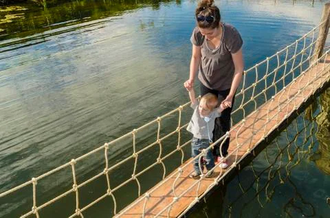 Happy child making first steps in a sunny afternoon on a footbridge Stock Photos