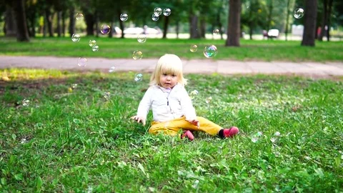 Happy child play with soap bubbles in spring park. Slow motion Stock Footage 84576085